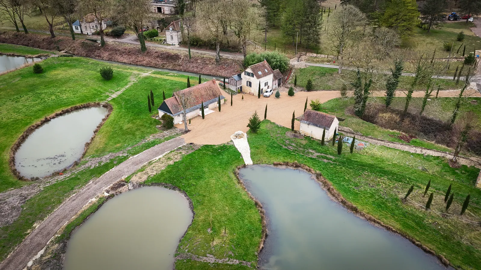 Vue aérienne des bâtiments, de la cour et des mares du domaine à La Haute Barde